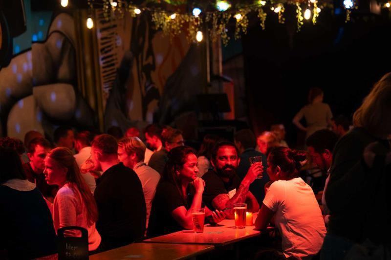 People drinking beer by the tables