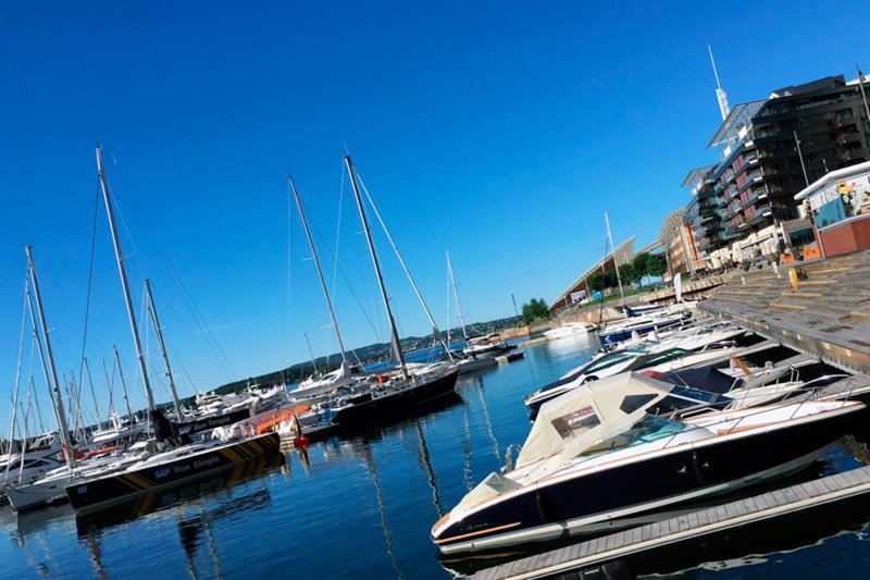 A pier with various boats ankered. Blue sky.