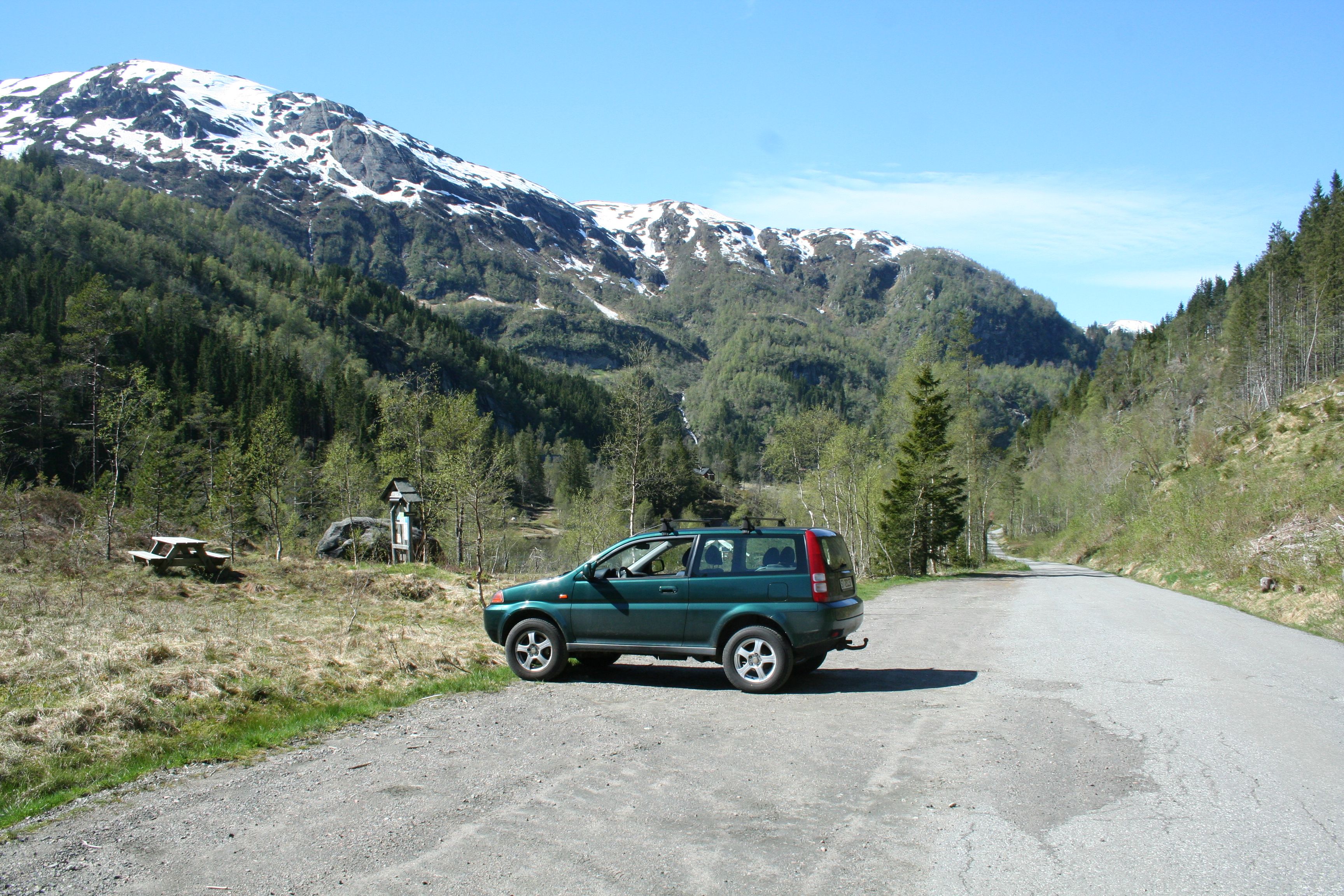 Parking spot in Fitjadalen surrounded by forest and mountains – a perfect base before hiking around Lake Fitjadalsvatnet.