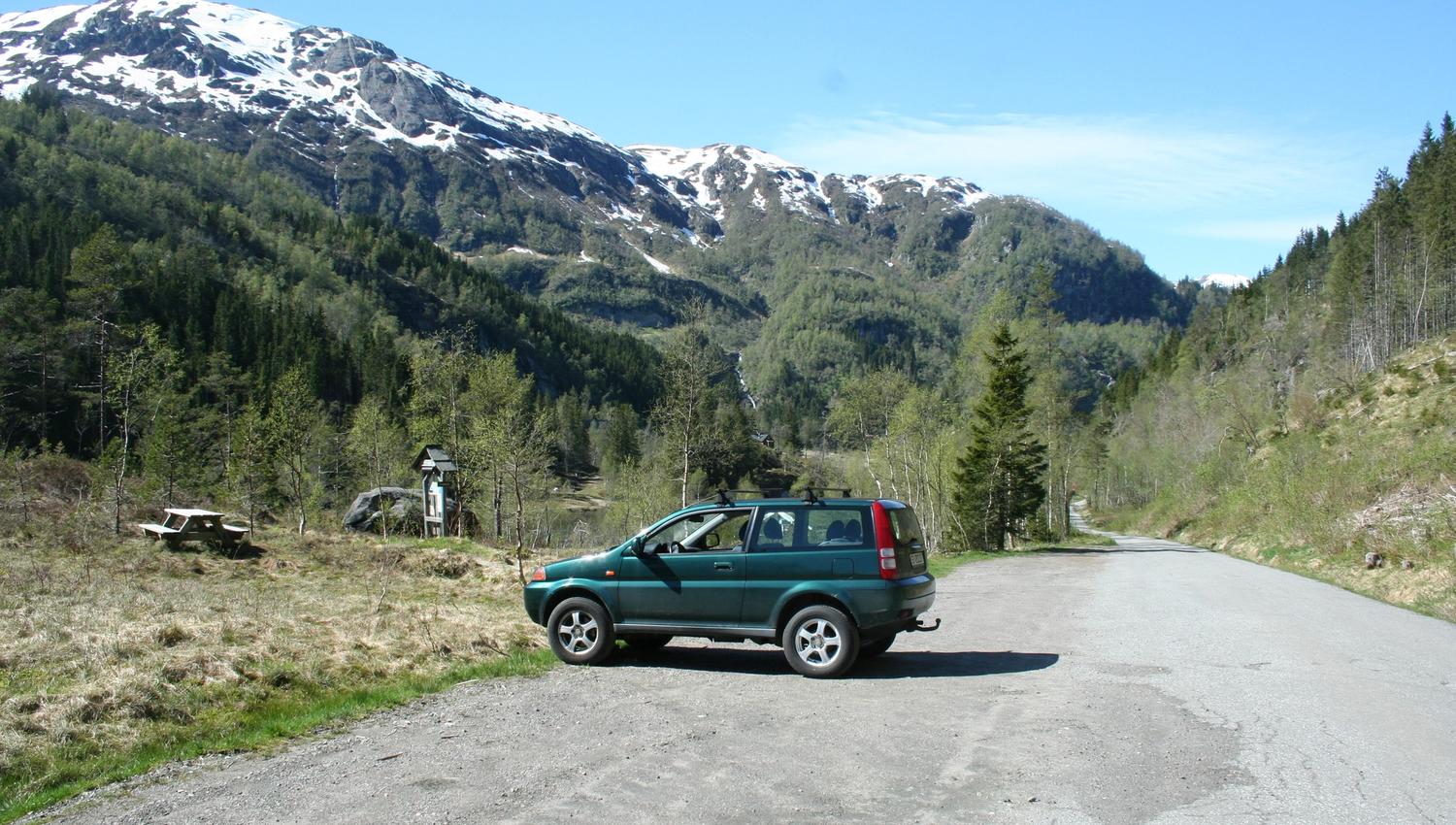 Parking spot in Fitjadalen surrounded by forest and mountains – a perfect base before hiking around Lake Fitjadalsvatnet.