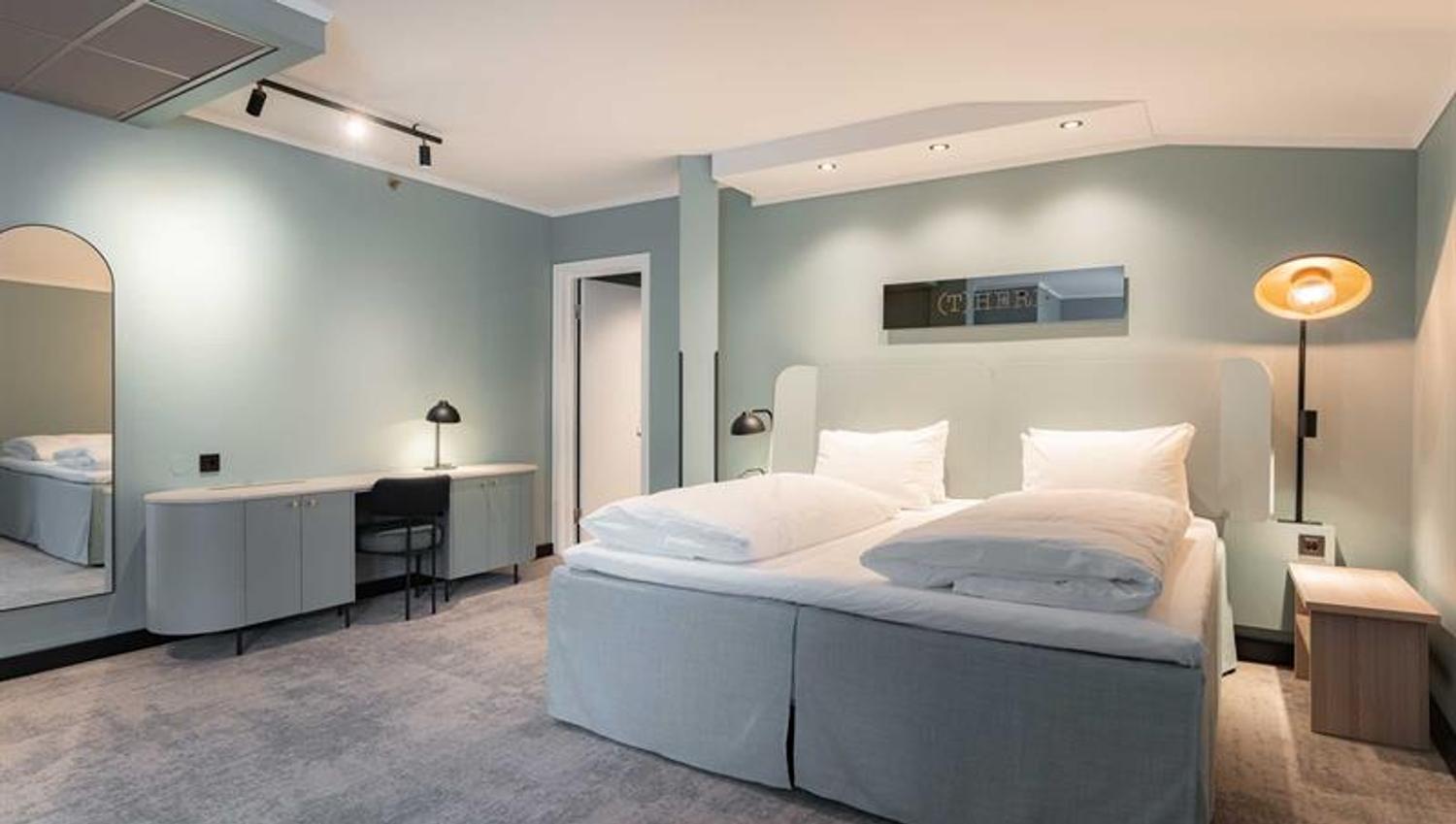 Junior suite with double bed and blue-green walls