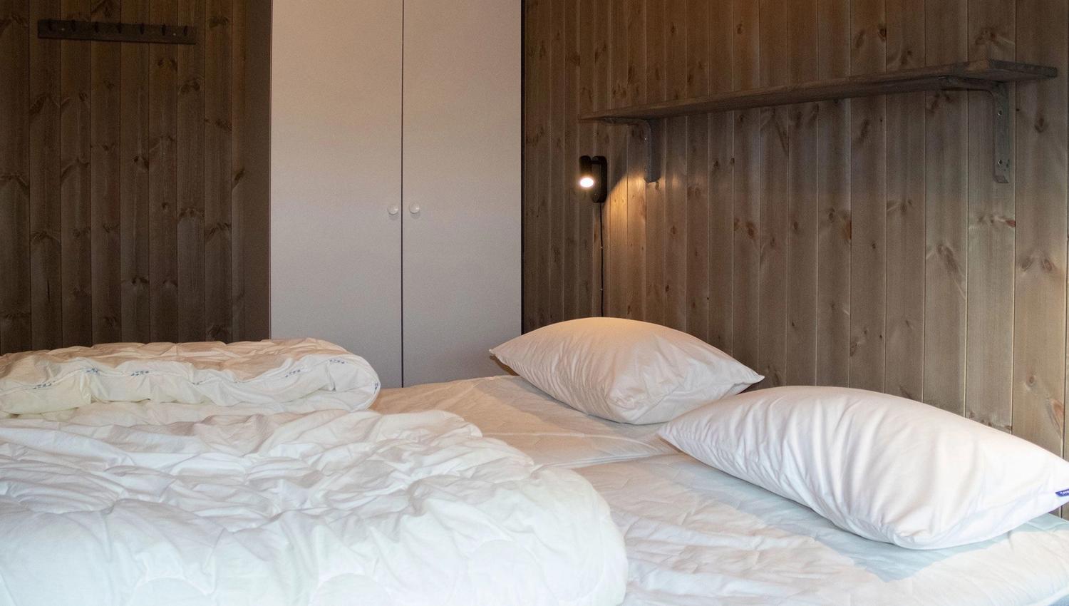 A bed with white sheets and pillows.