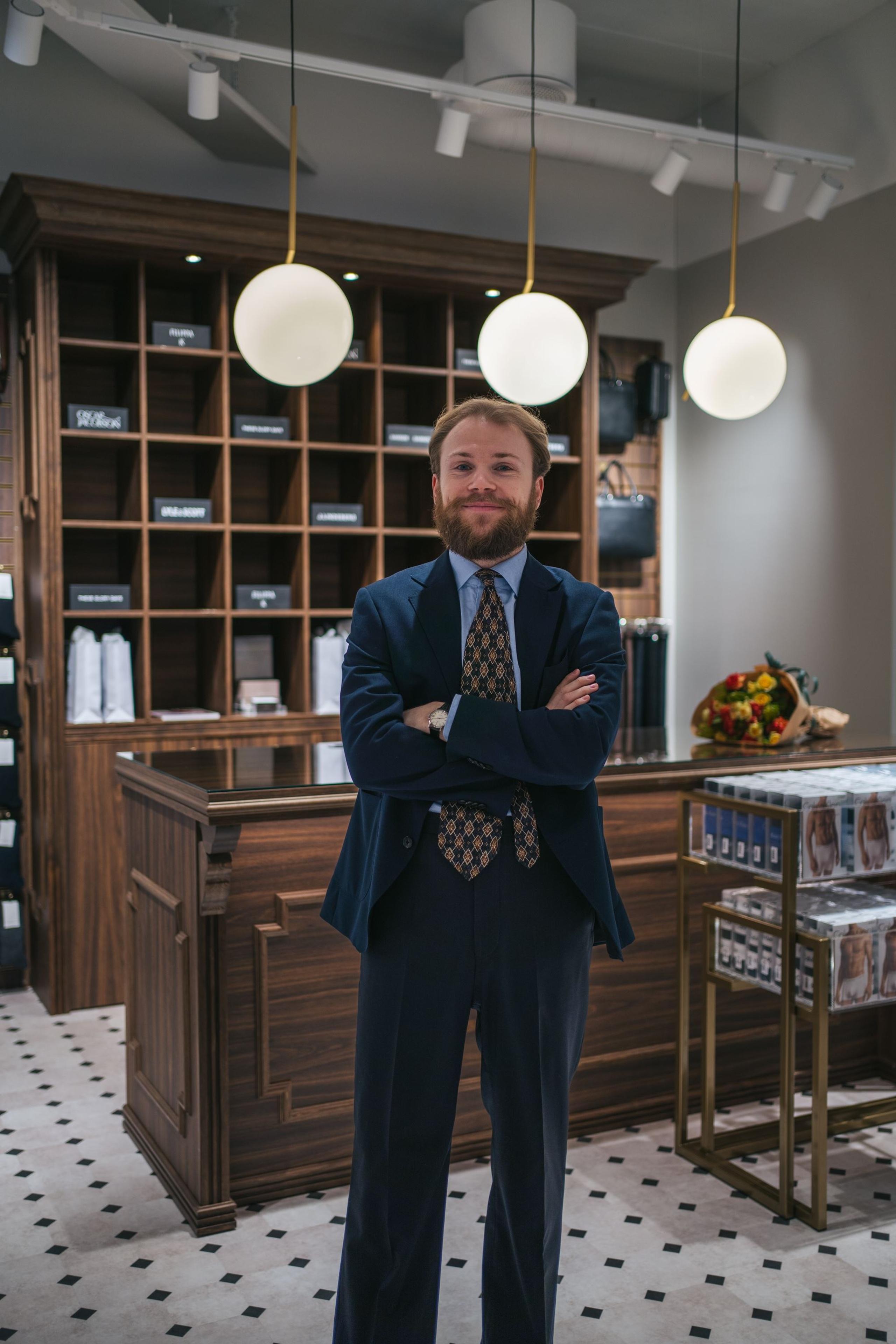 Ansatt poserer i butikken sin
