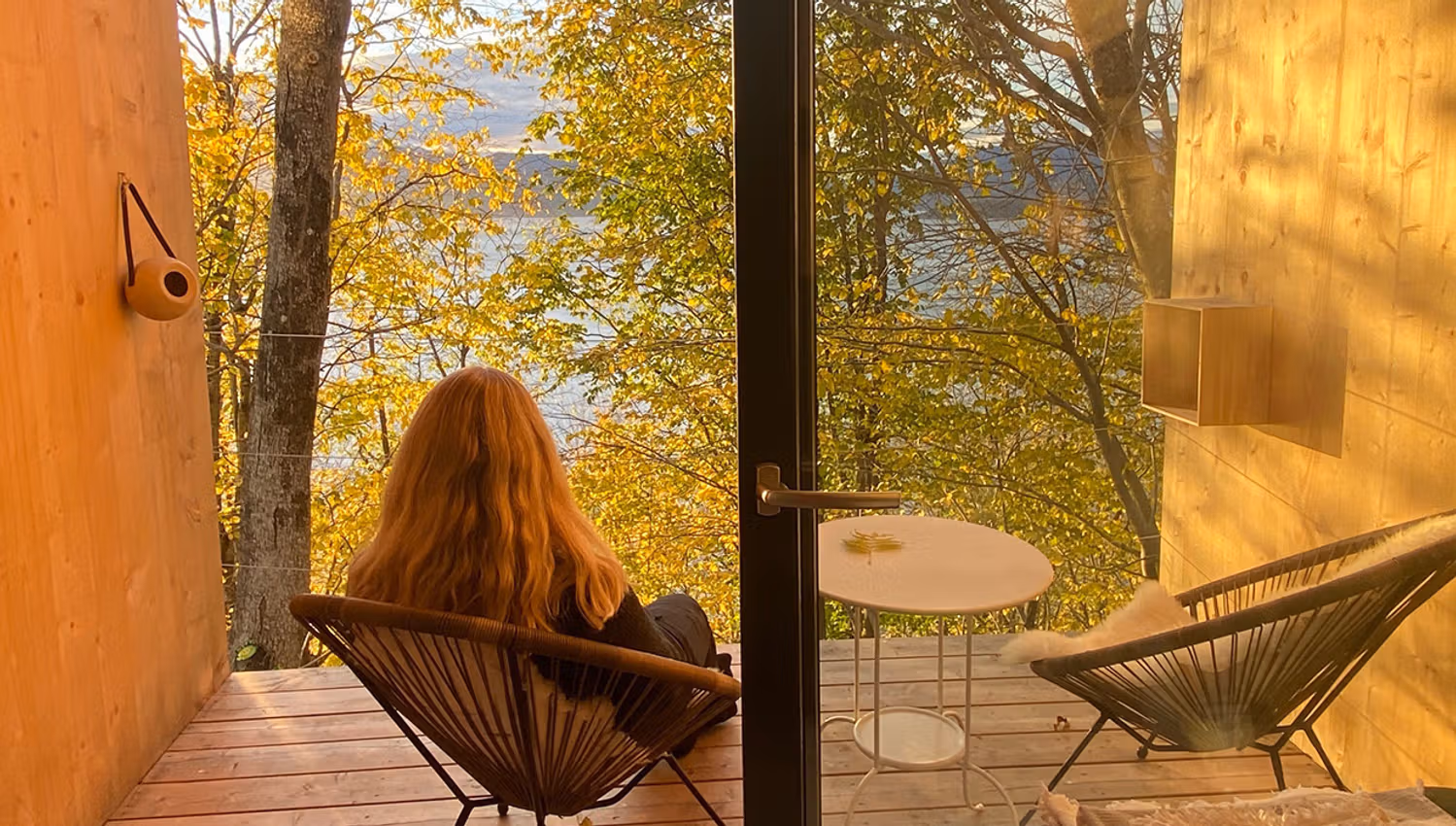 Guest enjoying the fjord view from the balcony in the cabin near Hardangerfjord.