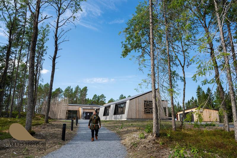 Sami man walking with the new museum buildings in the background