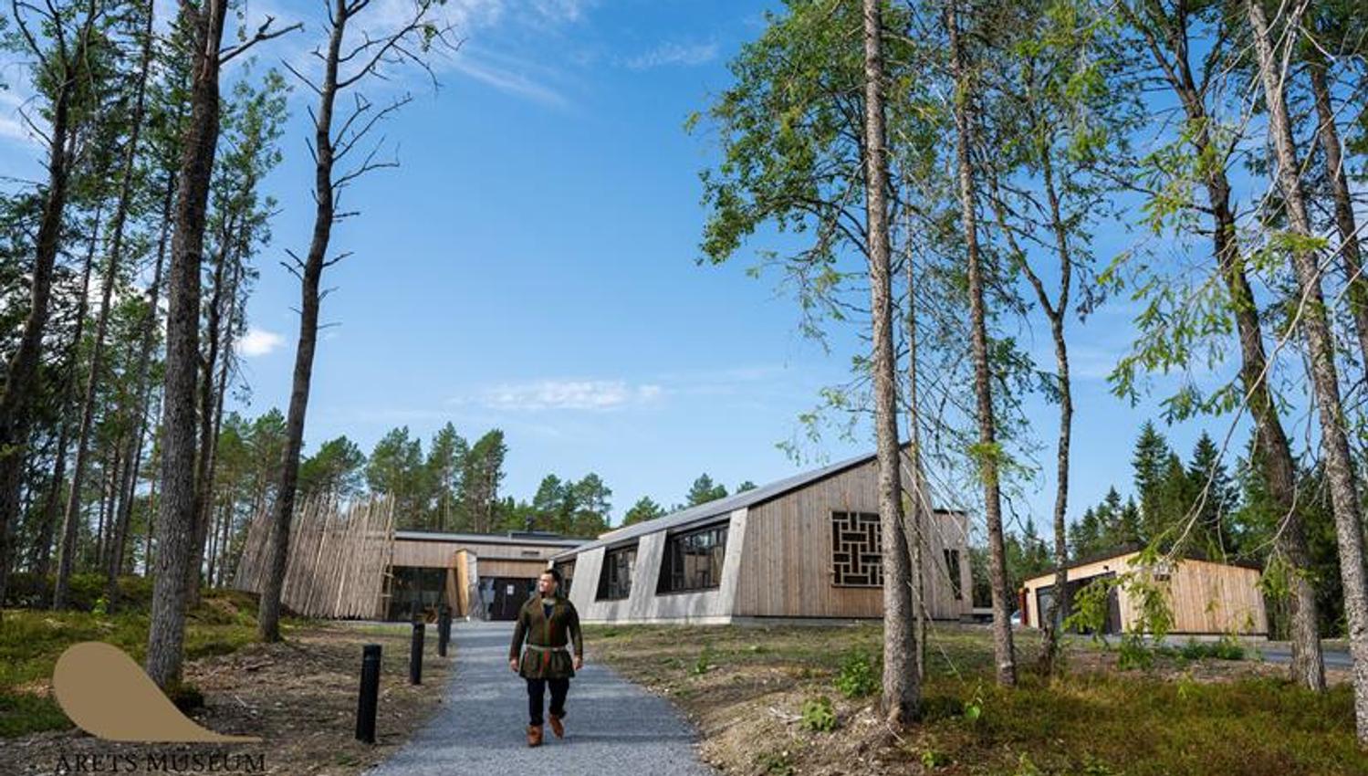 Sami man walking with the new museum buildings in the background