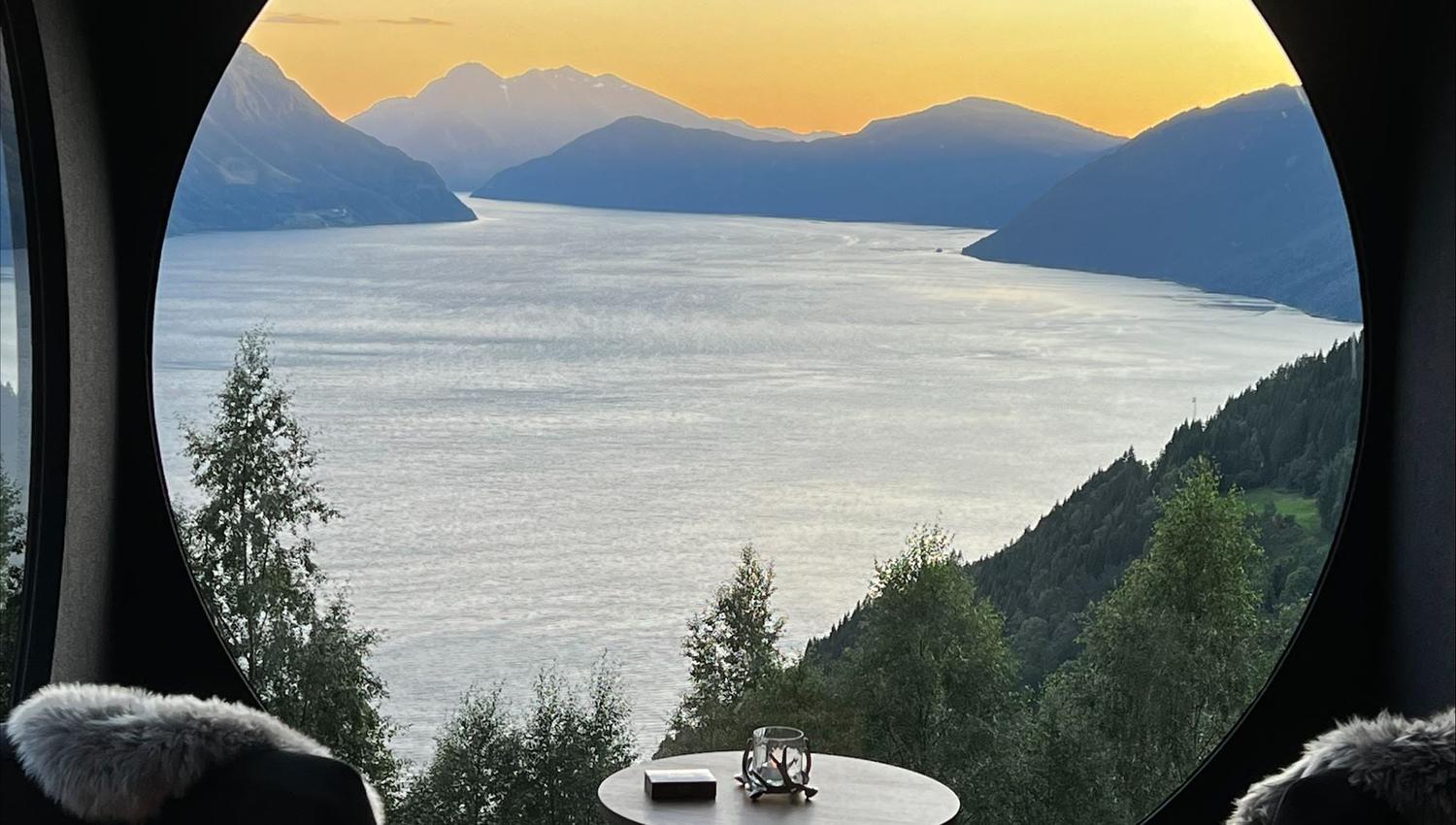 Stunning panoramic view from the Birdbox cabin at Skaara Living on Lotsberg in Nordfjord, surrounded by mountains and fjord landscape.