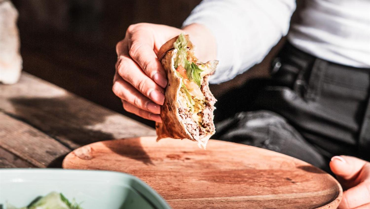 Hand placing a sandwich on a cutting board