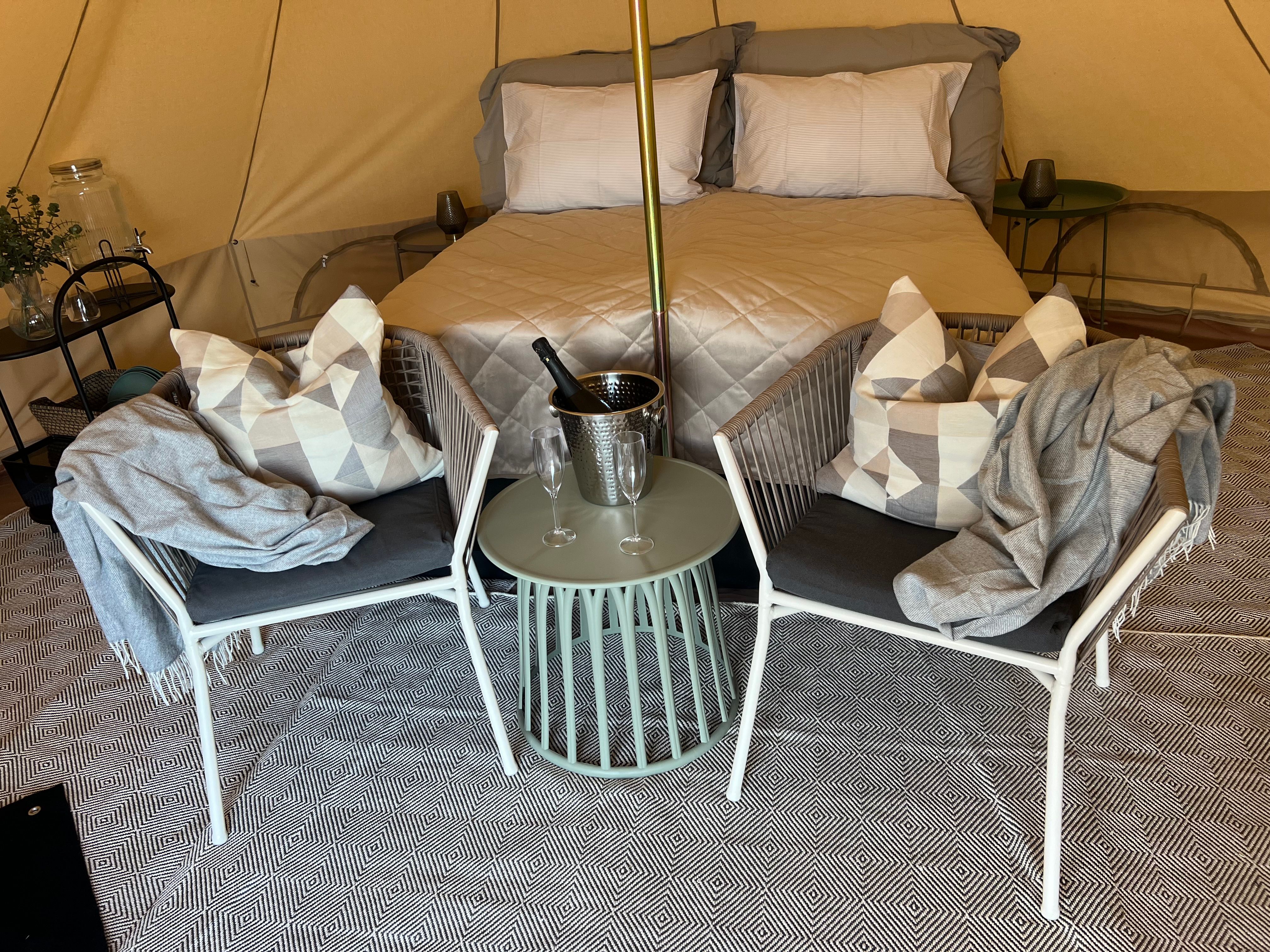 From inside the tent. Double bed, pillows, blanket, champagne cooler, carpet on the floor and a pleasant atmosphere.