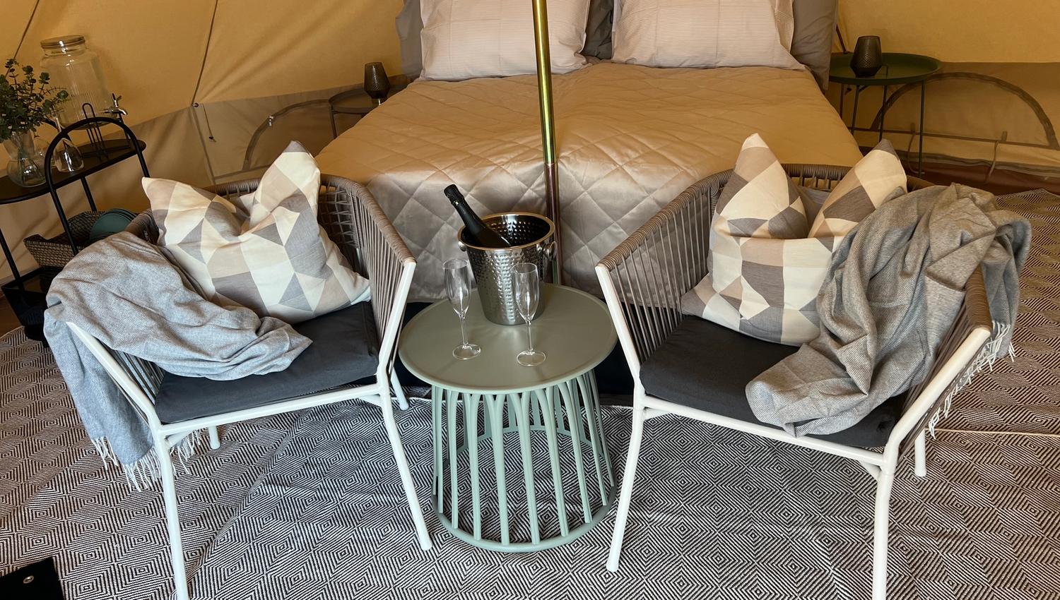 From inside the tent. Double bed, pillows, blanket, champagne cooler, carpet on the floor and a pleasant atmosphere.
