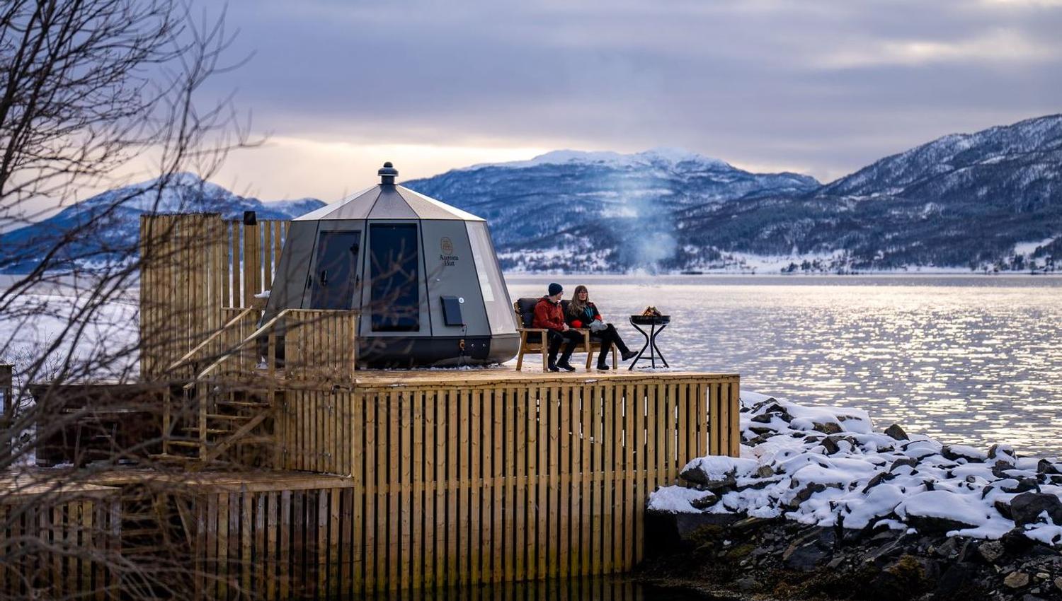 Guests sitting on dock by a little hut