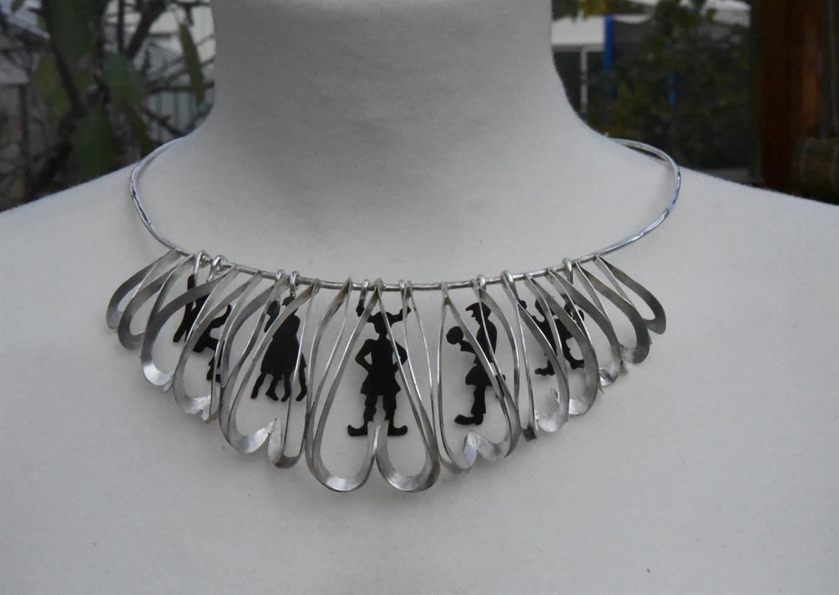  Metal and glass necklace with decorative hanging shapes.