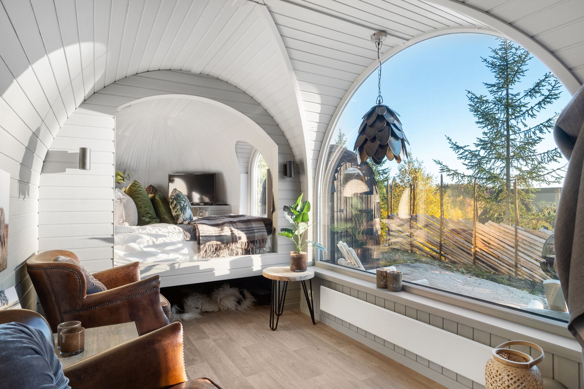bed, chairs and a big panorama window with view 