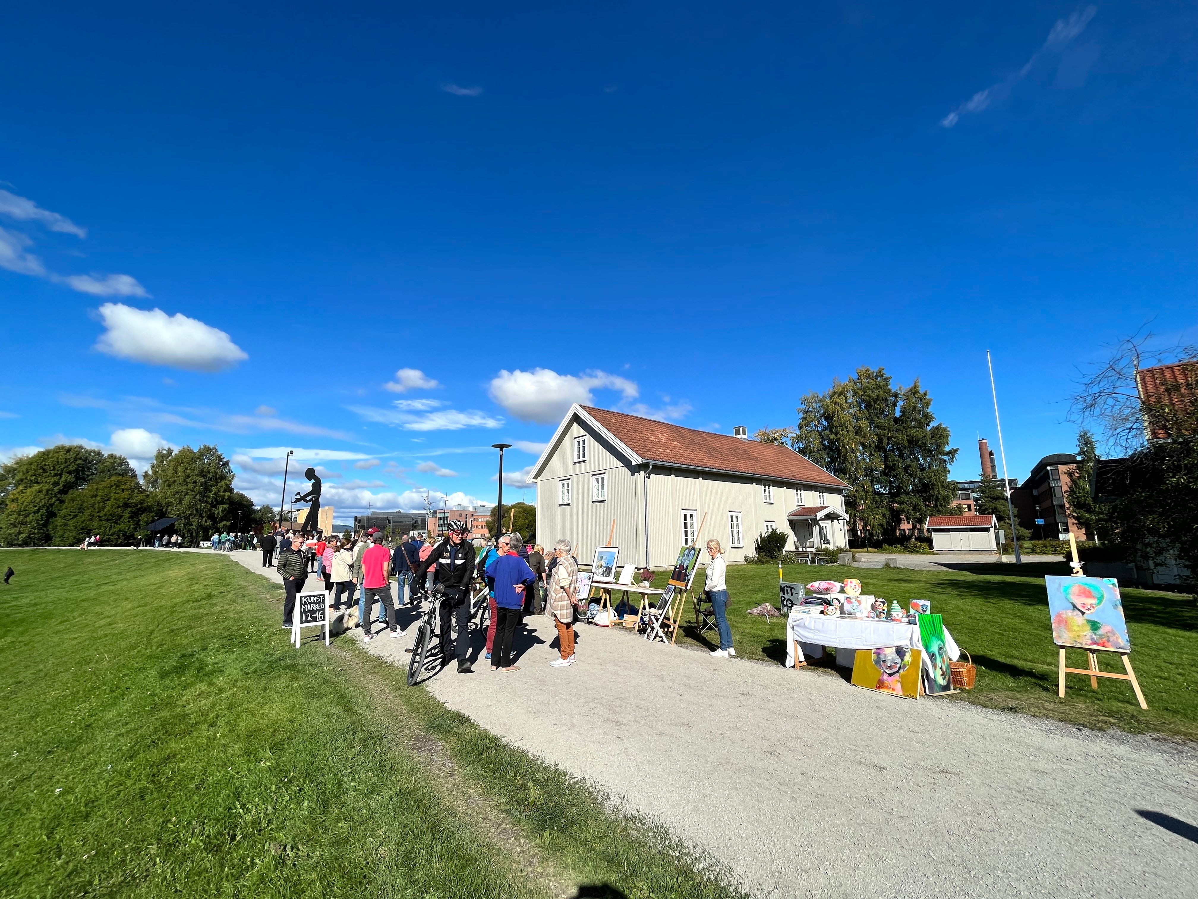 People walking on a road with a grey house in the background
