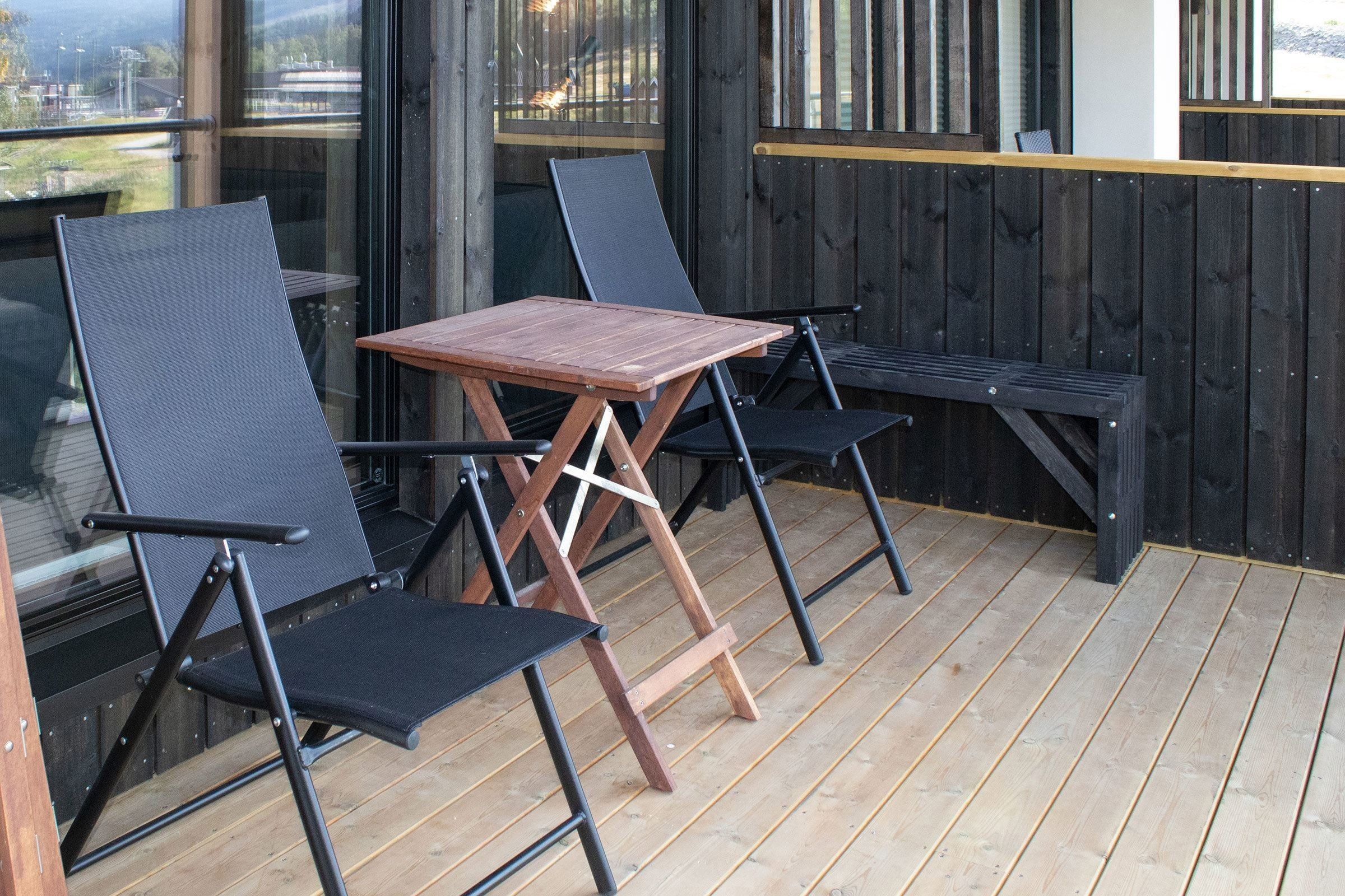 Ein Tisch und Stühle auf einer Terrasse.