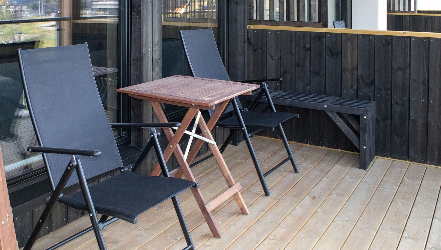 Ein Tisch und Stühle auf einer Terrasse.