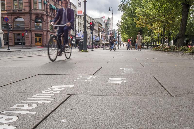 Cyclists and pedestrians moving along Karl Johans gate.