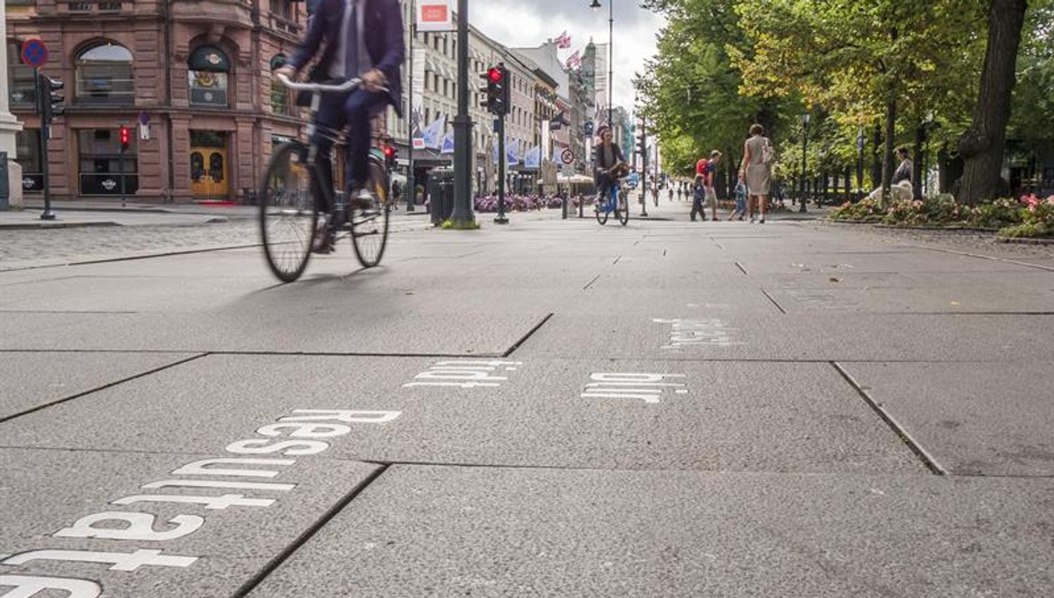 Cyclists and pedestrians moving along Karl Johans gate.