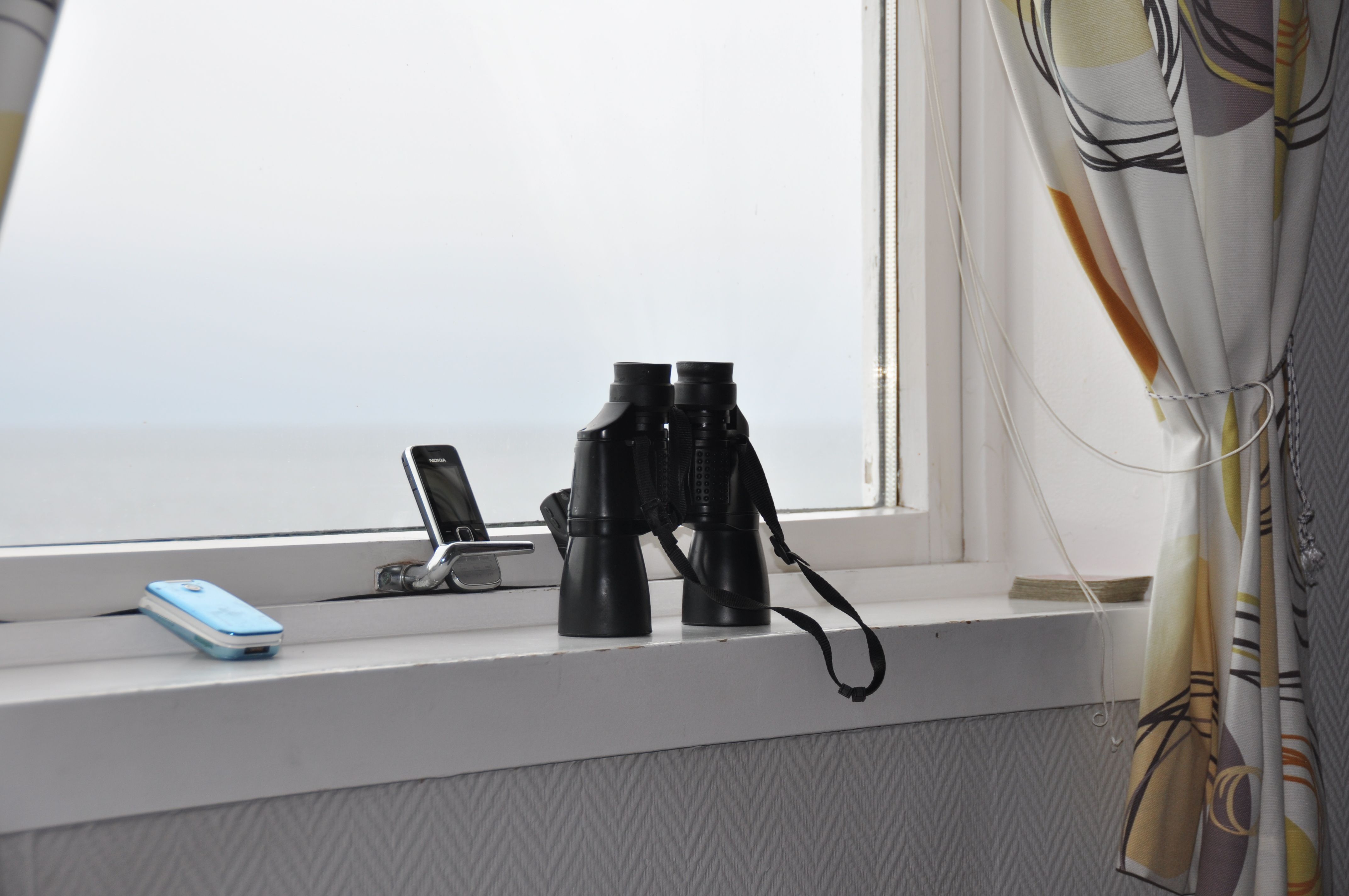 Telefon og kikkert i vinduskarm på Nordøyan fyr.