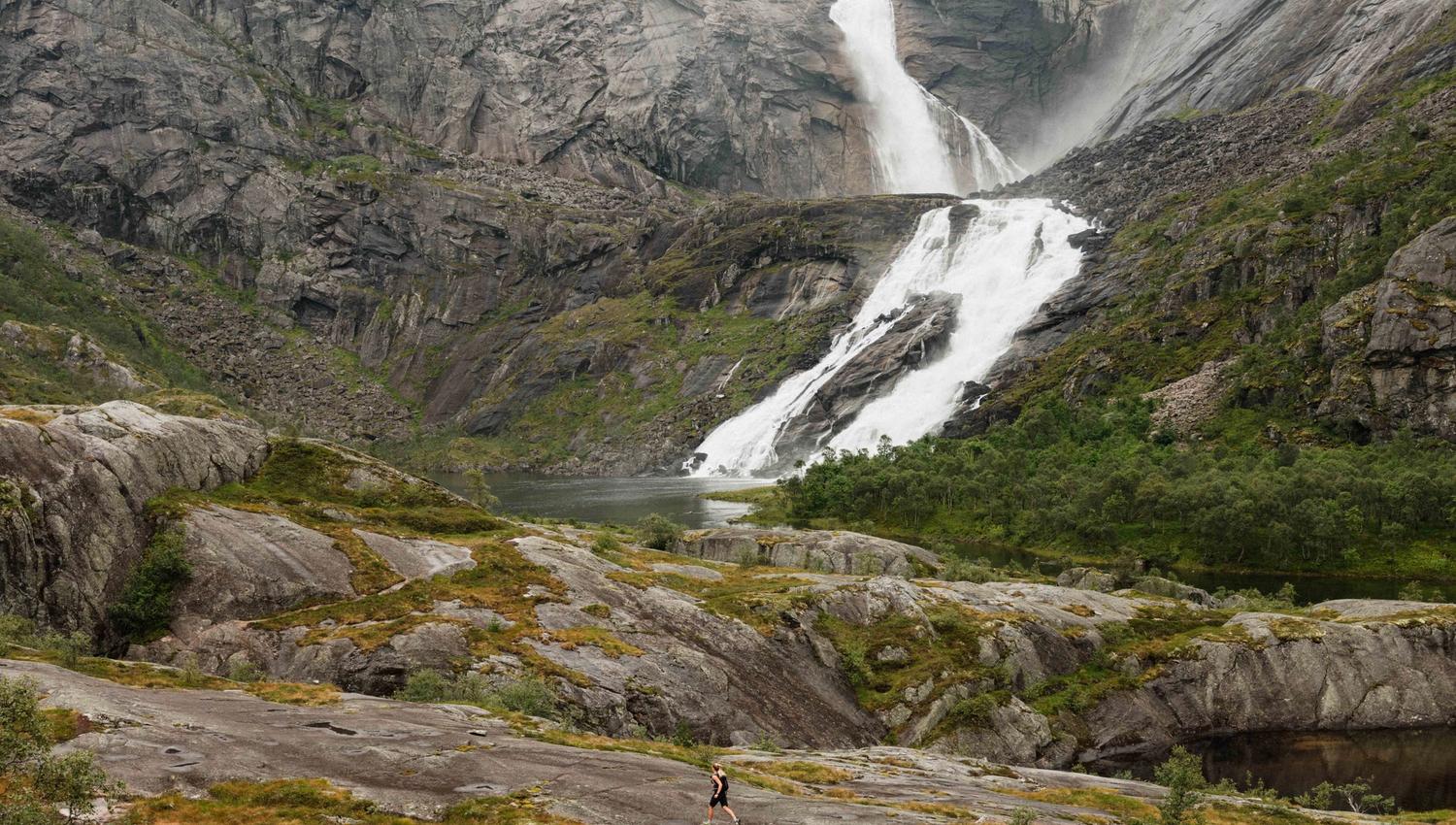 A hiker approaches Nyastølsfossen – a majestic waterfall at the upper end of the Husedalen Valley.