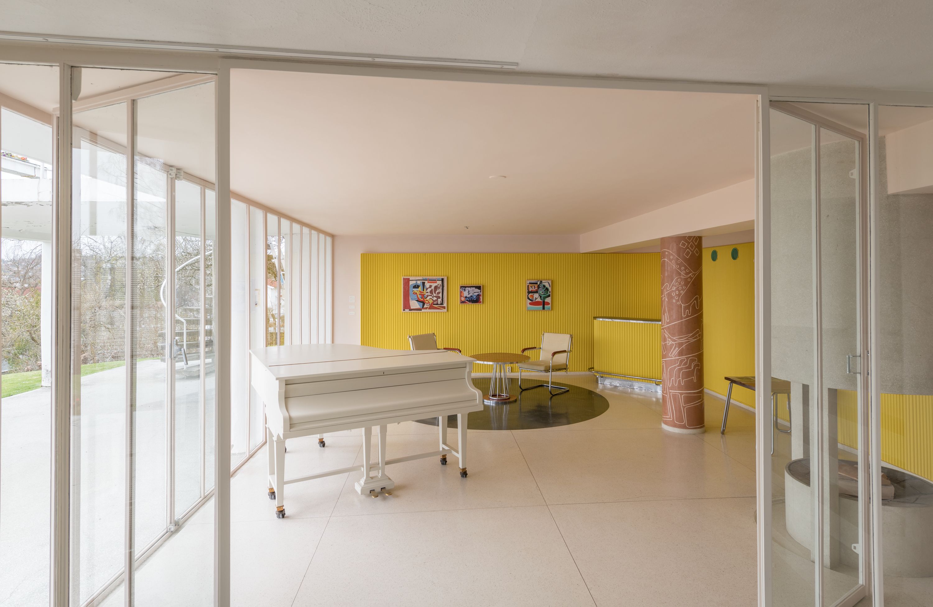 Living room with white grand piano and panoramic window