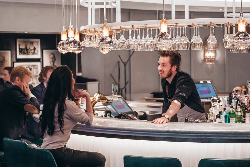 Bartender and guests, Bar Boman, Hotel Continental, Oslo. 