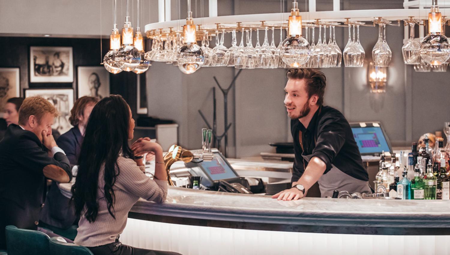 Bartender and guests, Bar Boman, Hotel Continental, Oslo.