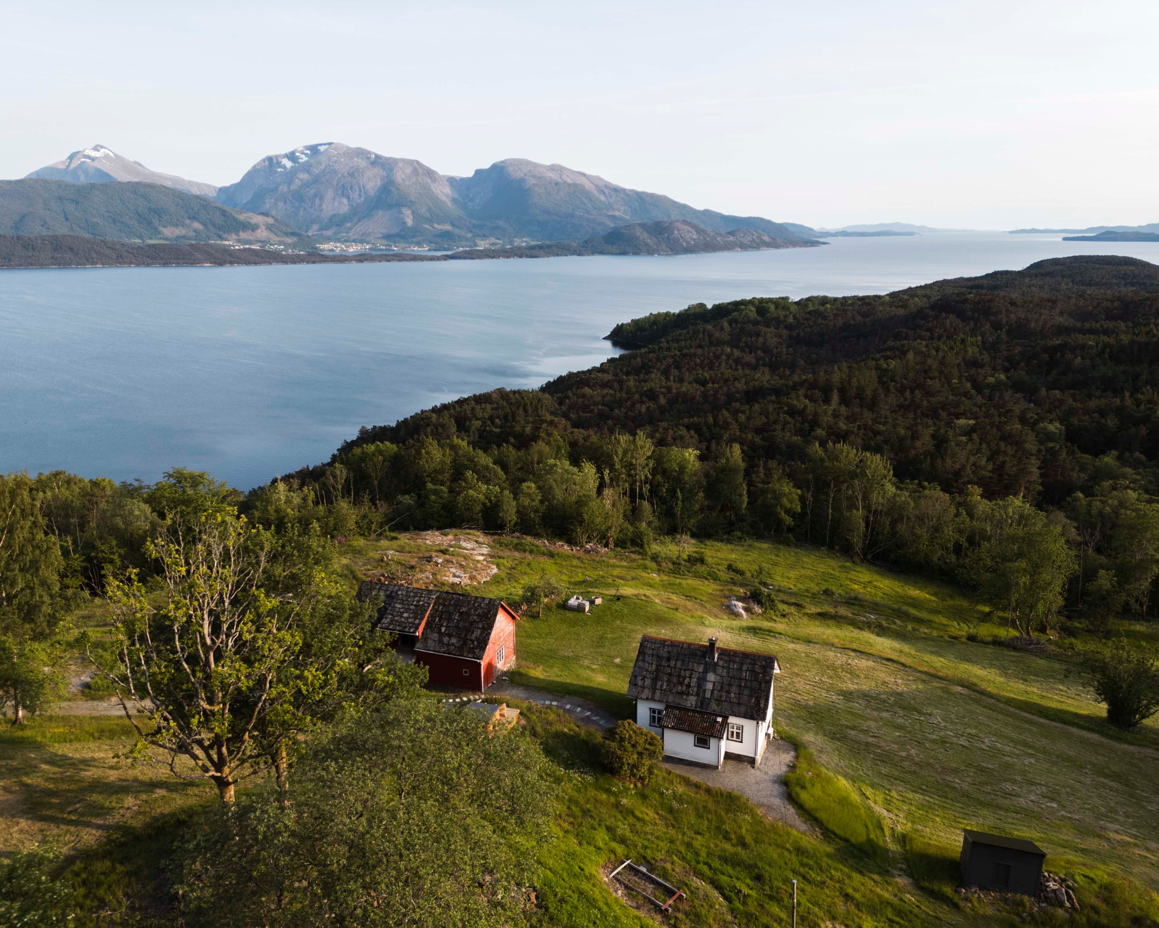 Aerial view of Stigen Fjordlodge with fjord and mountain scenery in Hardanger.