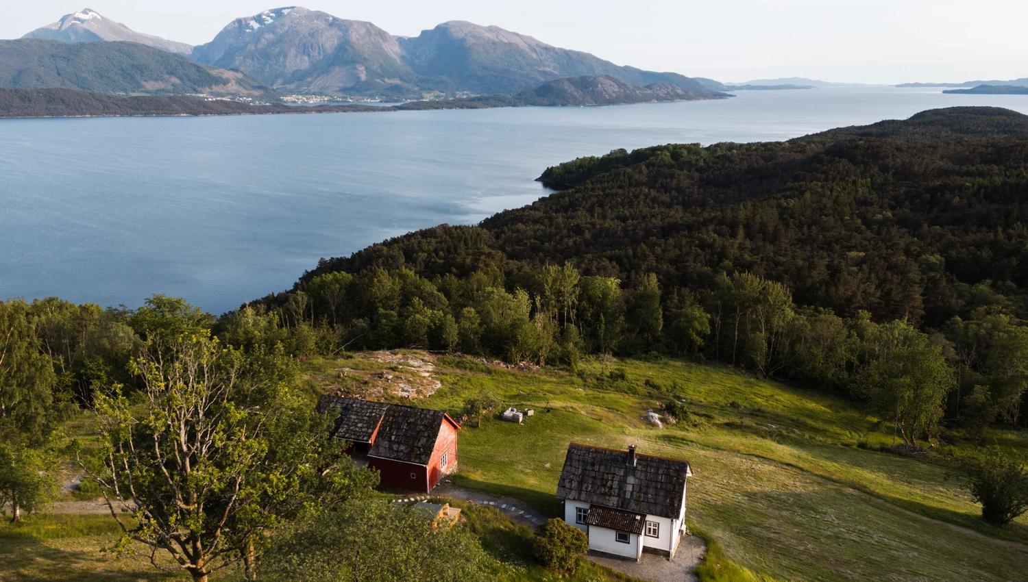Aerial view of Stigen Fjordlodge with fjord and mountain scenery in Hardanger.