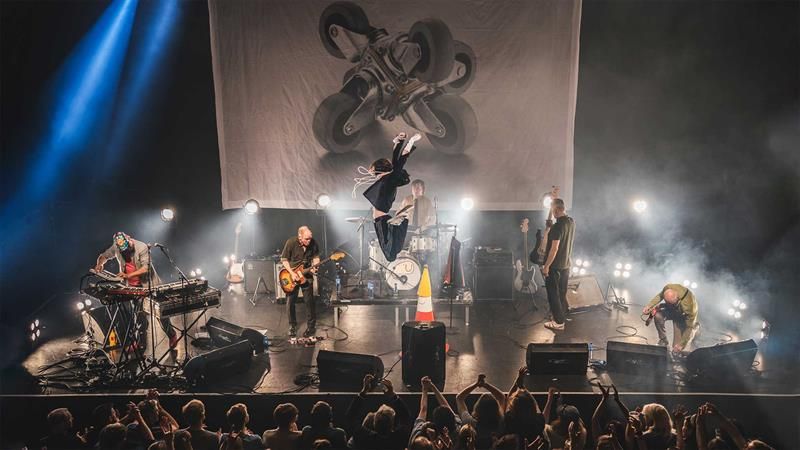 The lead singer of Bob Hund jumping on stage while the band is playing
