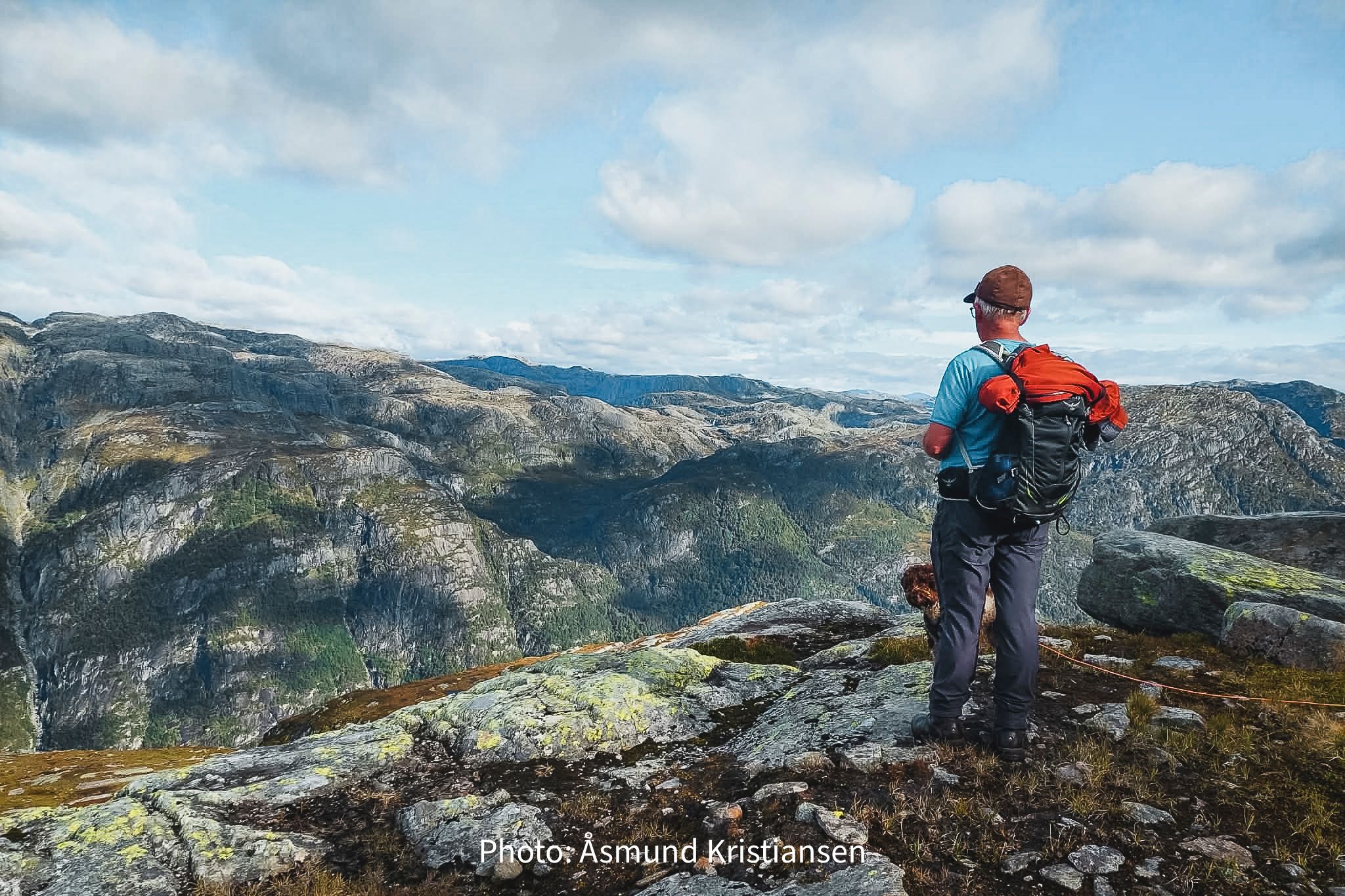 Hiker with backpack enjoying panoramic mountain views in Hardanger, Norway, a prime destination for hiking