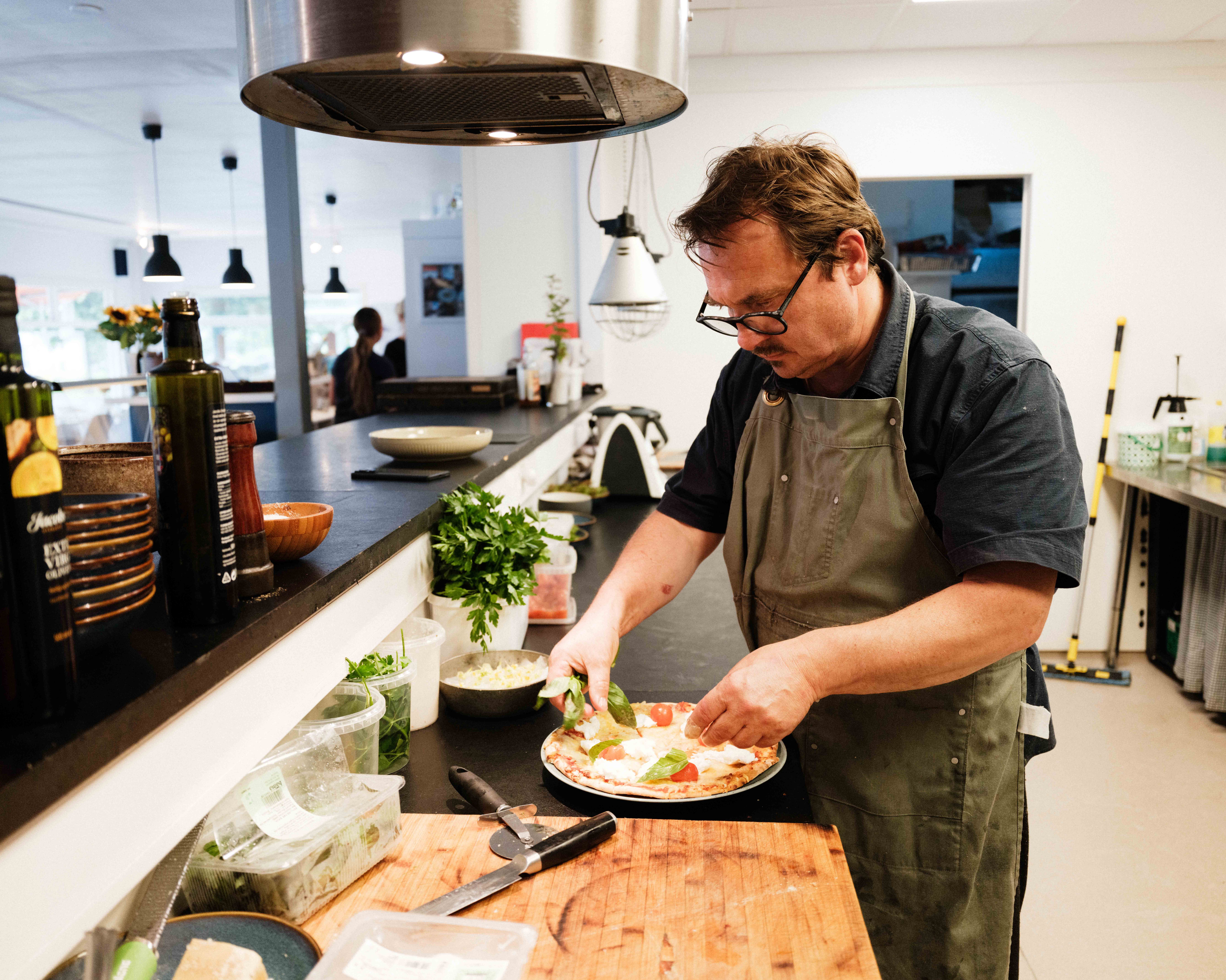 The chef adds the final toppings to a freshly made pizza at Gløyp Spiseri in Kinsarvik.