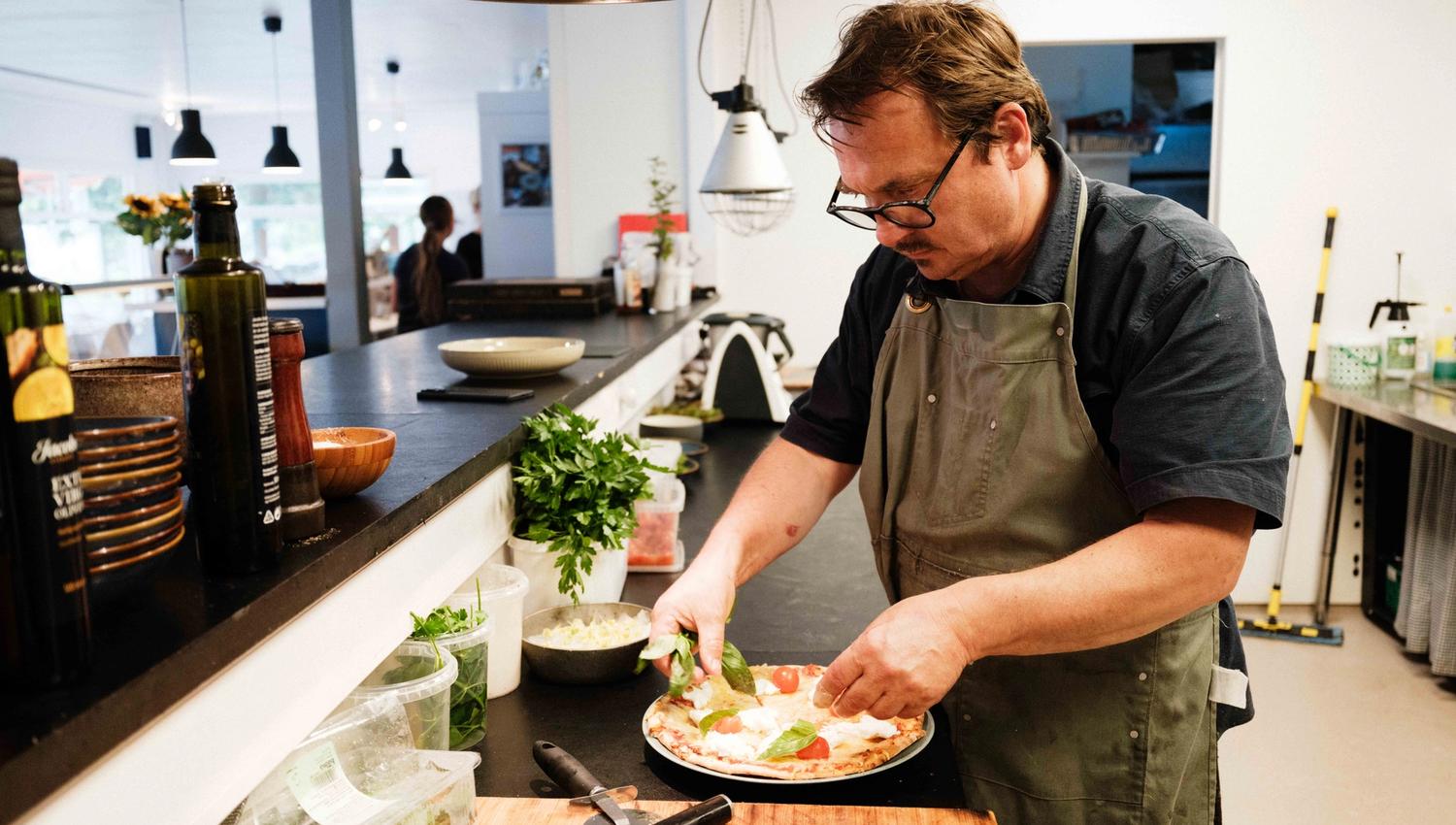 The chef adds the final toppings to a freshly made pizza at Gløyp Spiseri in Kinsarvik.