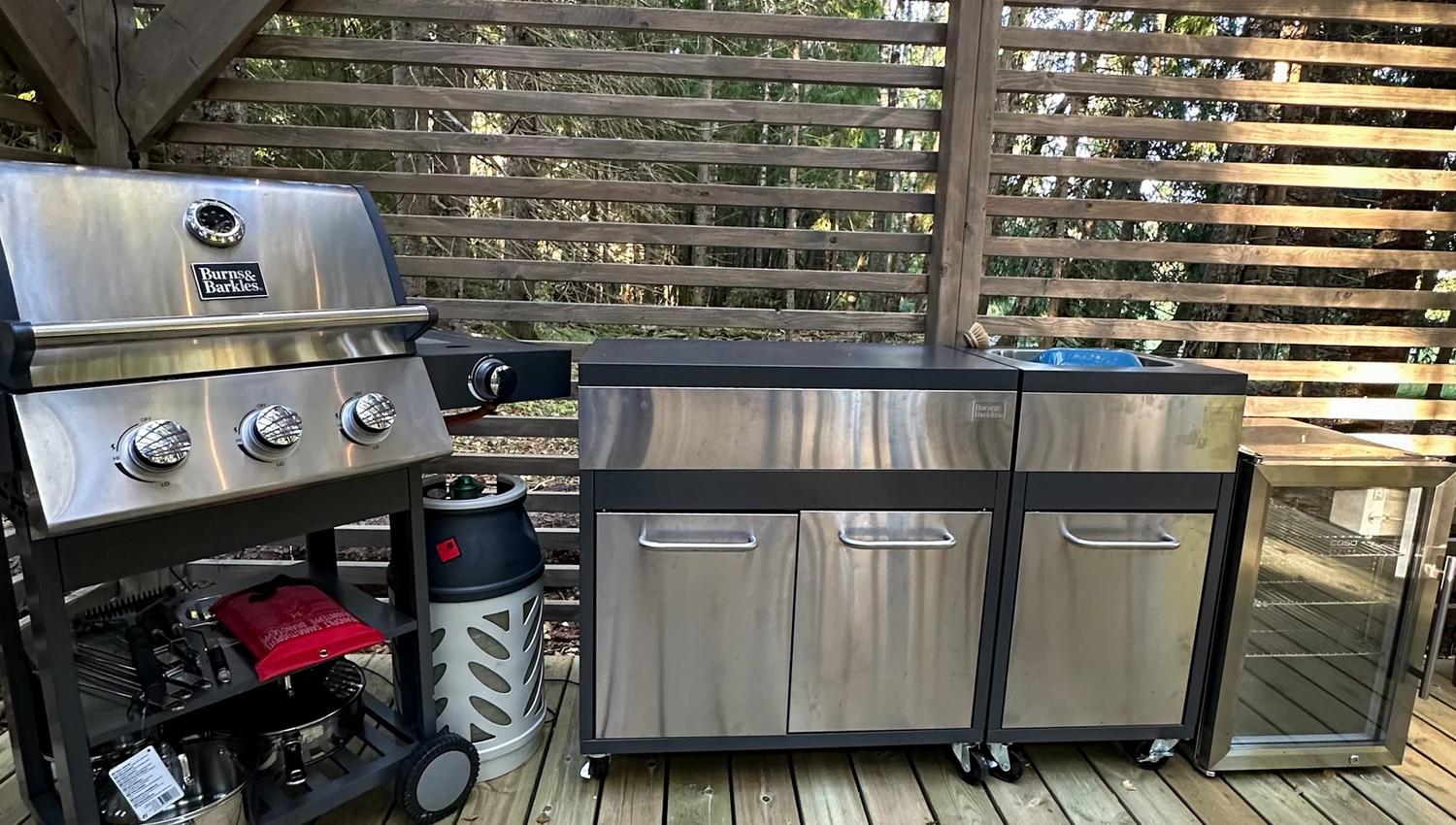Gas grill, cupboard and small fridge on the patio