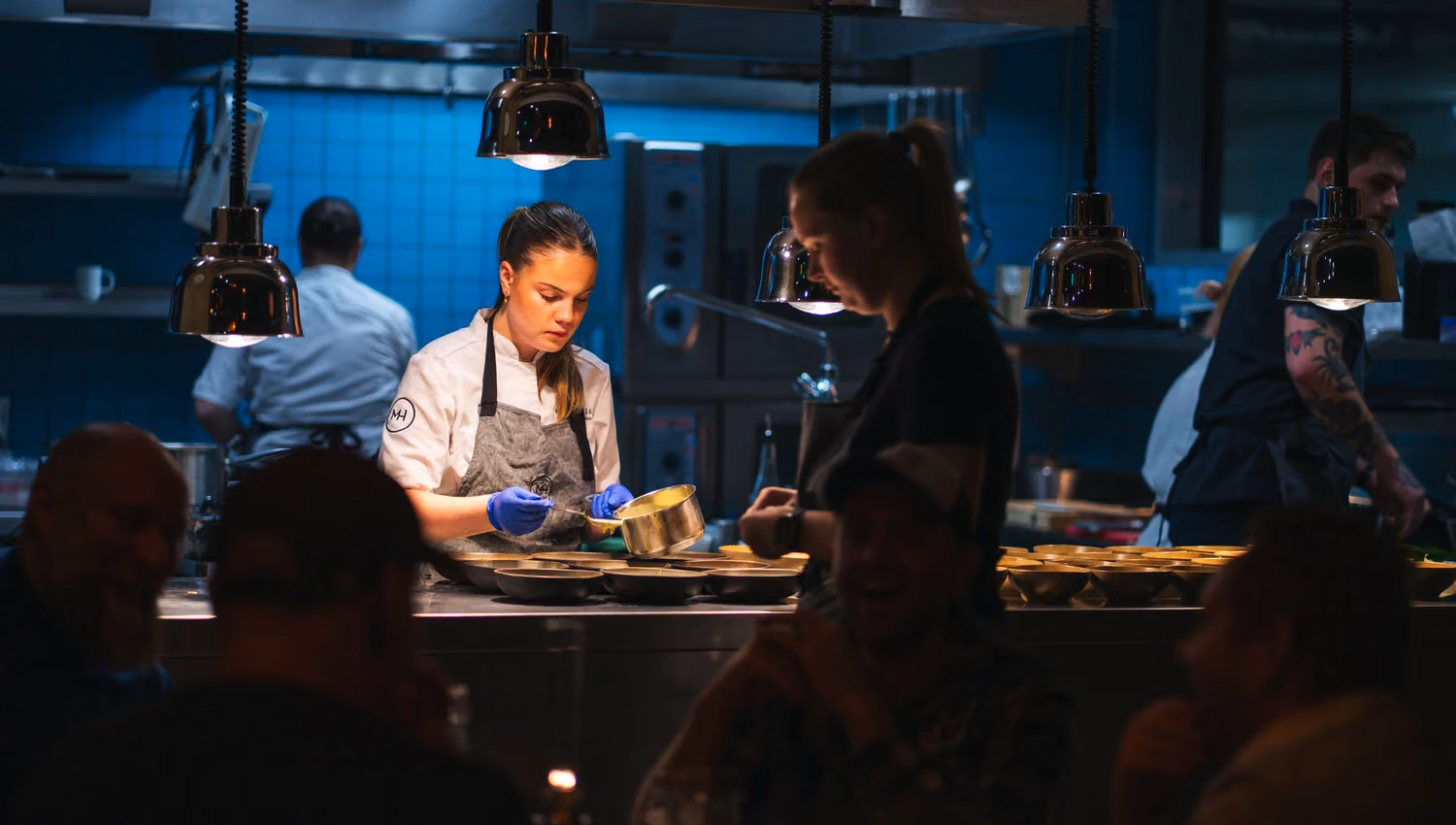 A chef serving a dish to guests at Mathallen Tromsø.