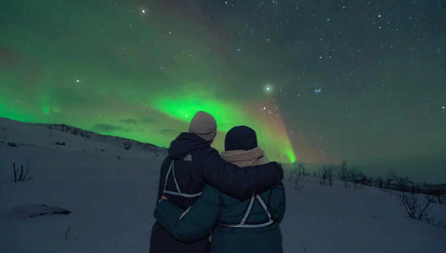 Two people watching Northern Lights
