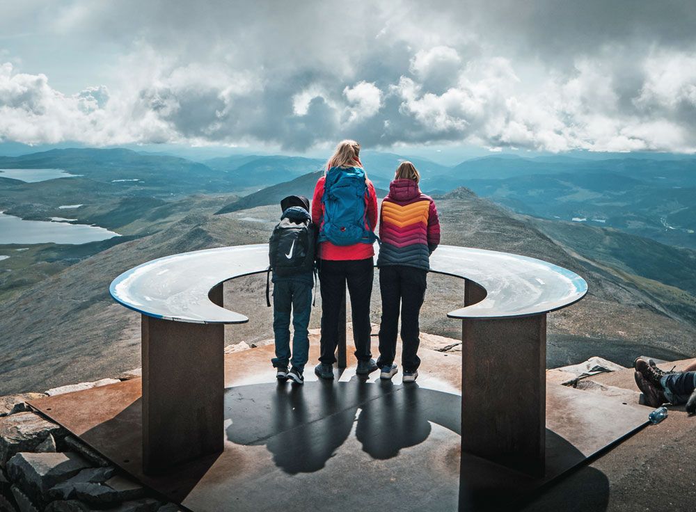 lady and 2 children stand on top of Mount Gausta 