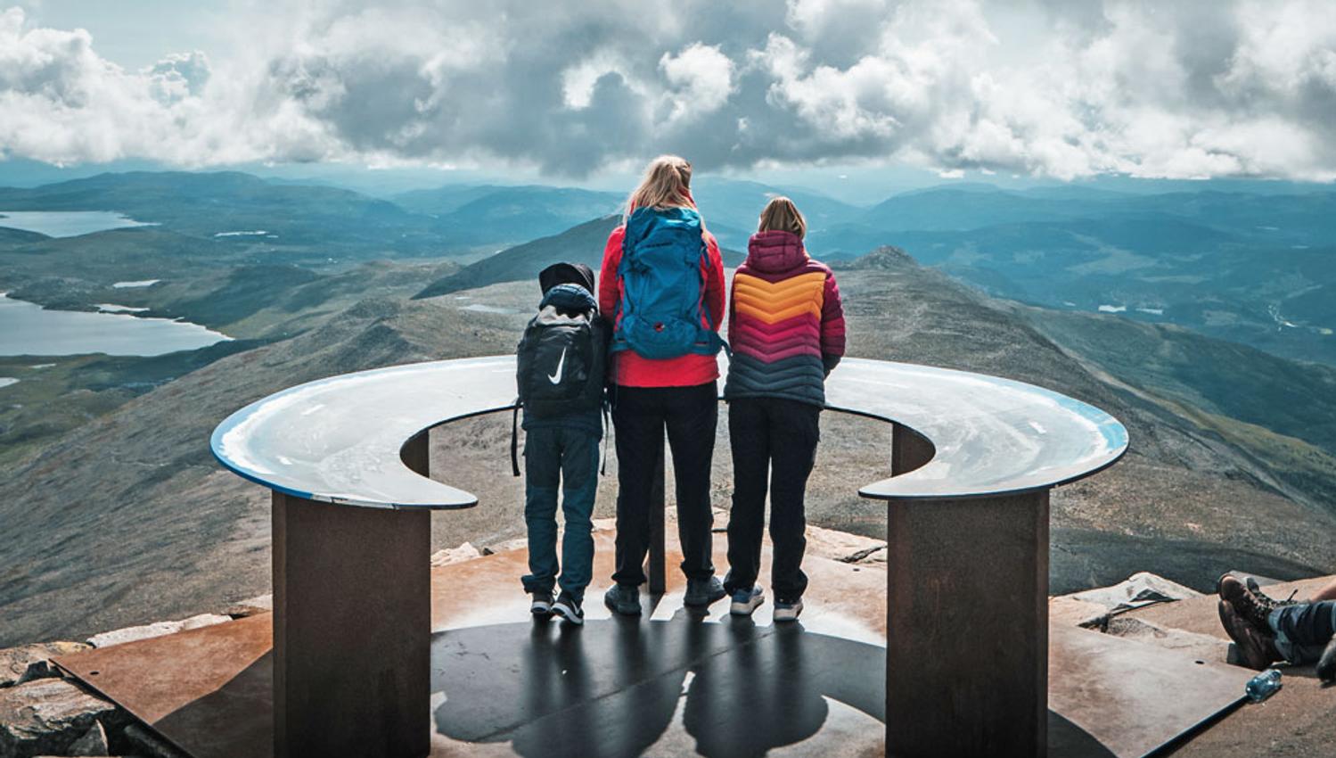 lady and 2 children stand on top of Mount Gausta