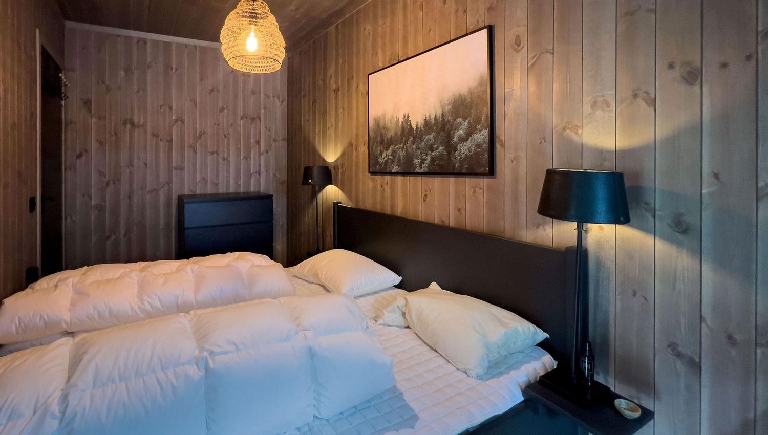 Ein Bett mit weißen Laken und einer Lampe in einem Zimmer.