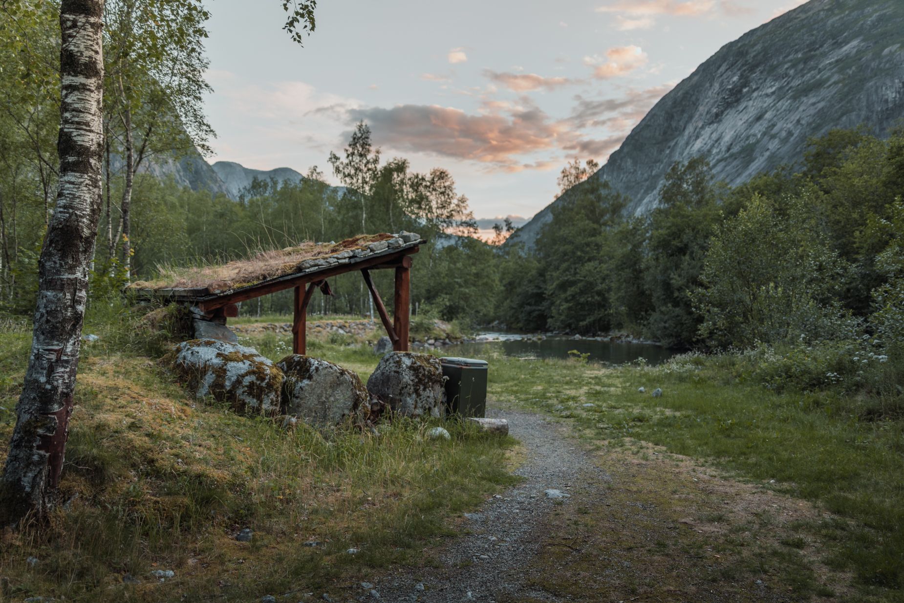 A fishing shelter by the river at sunset.