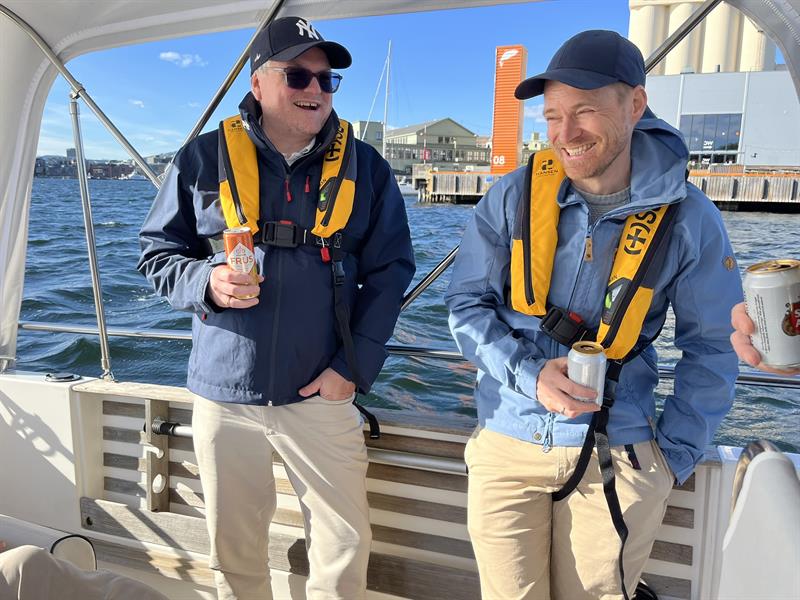 Two happy boat guests with life jackets on deck