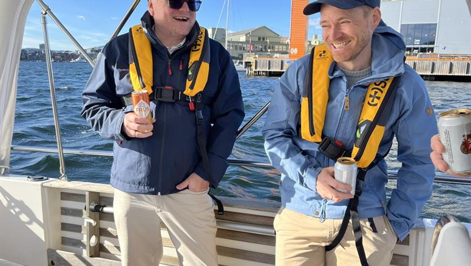Two happy boat guests with life jackets on deck