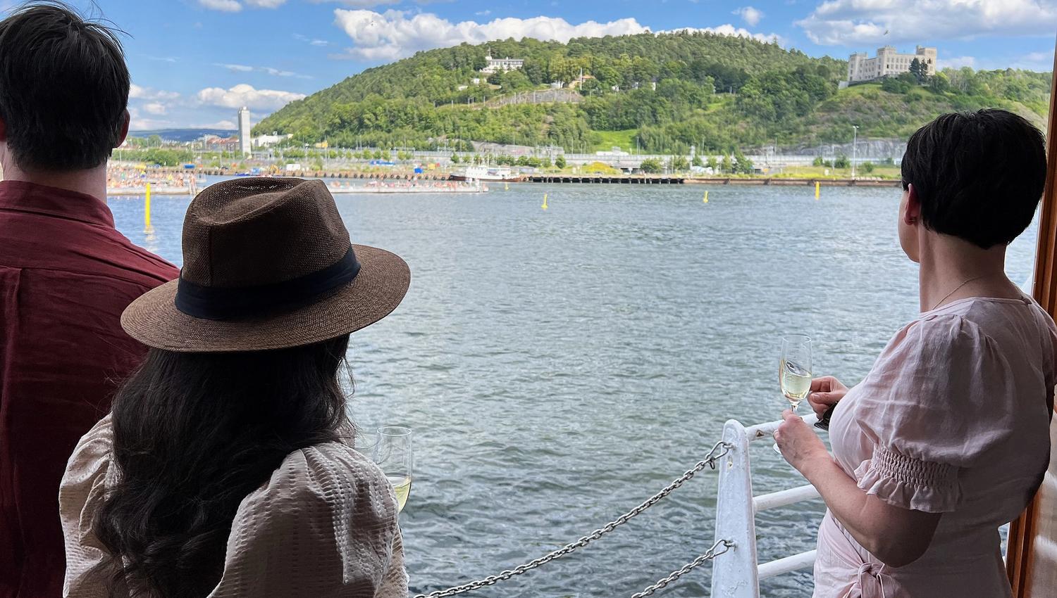 Three people looking towards the city from the boat