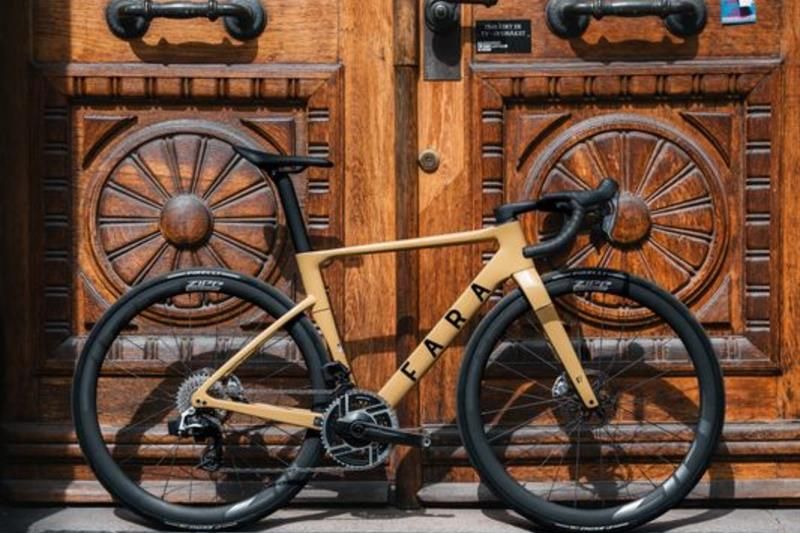 A yellow bicycle leaning against a large wooden door with carvings in it