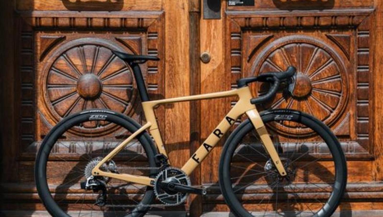 A yellow bicycle leaning against a large wooden door with carvings in it
