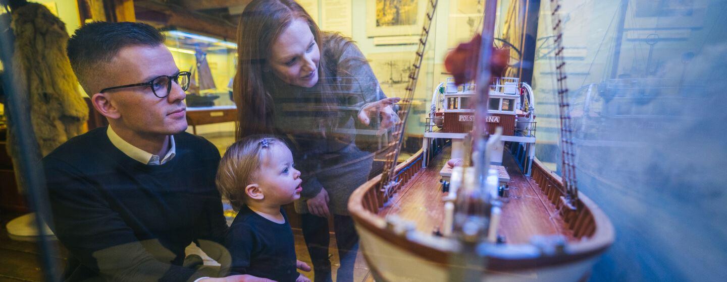 Family studying the exhibition at the Polar Museum in Tromso