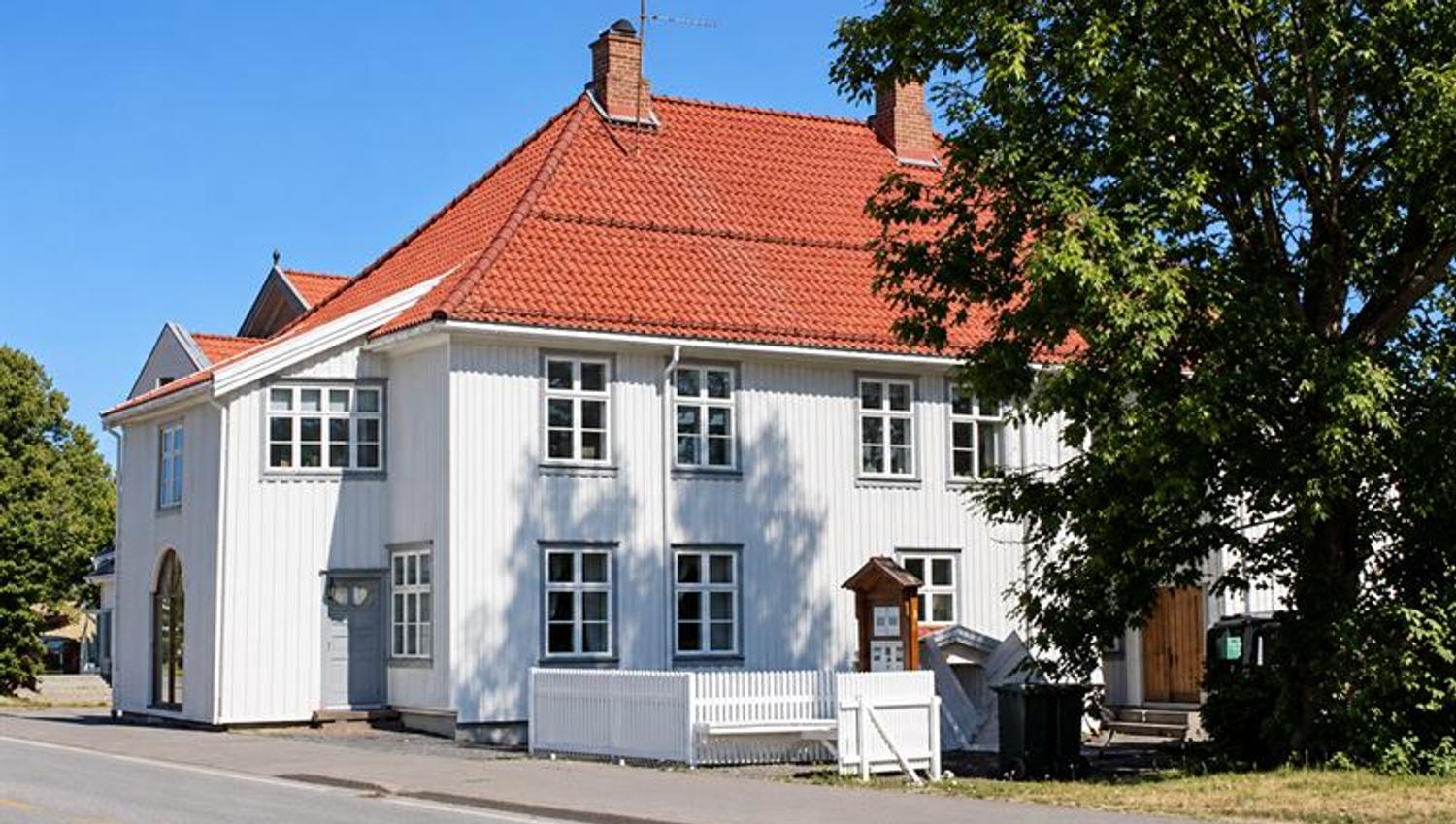 Holmestrand Museum in a white wooden building with a red tiled roof in the town centre.