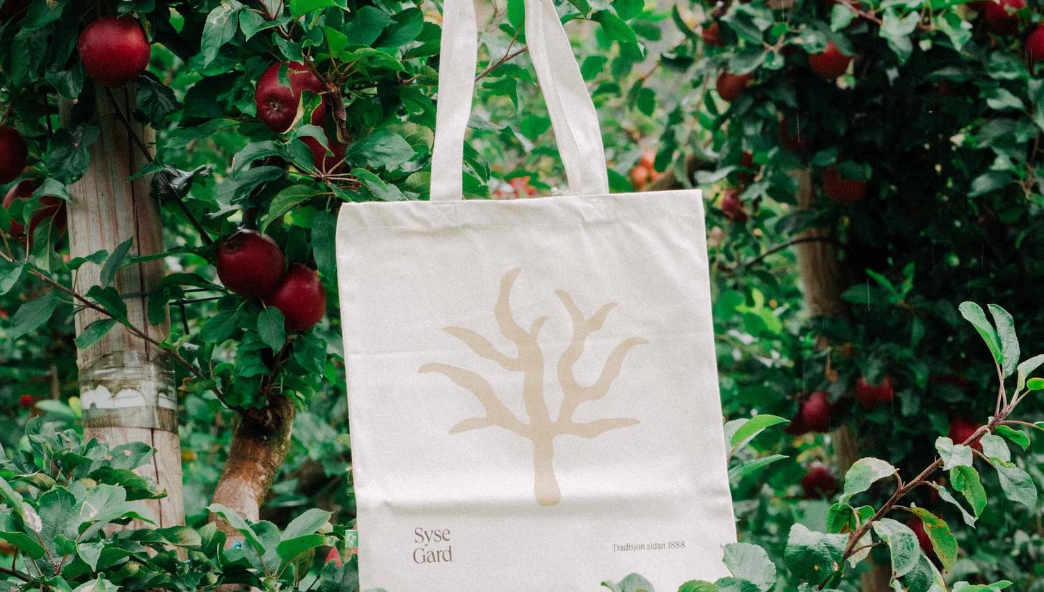 Tote bag from Syse Gard hanging among the apple trees in the orchard.