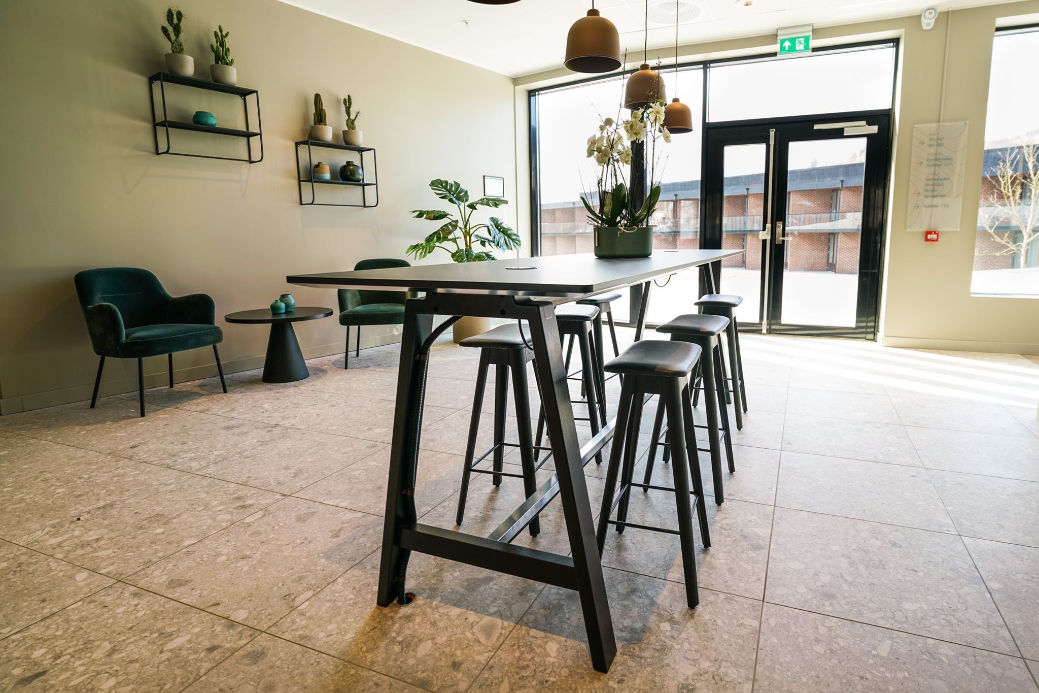 Entrance area with high tables, hanging lamps, and stylish interior design.