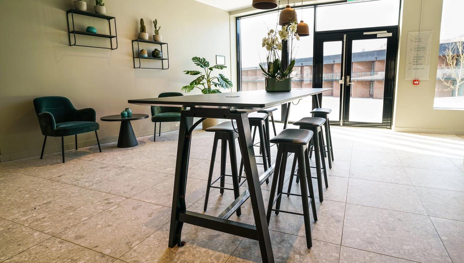Entrance area with high tables, hanging lamps, and stylish interior design.